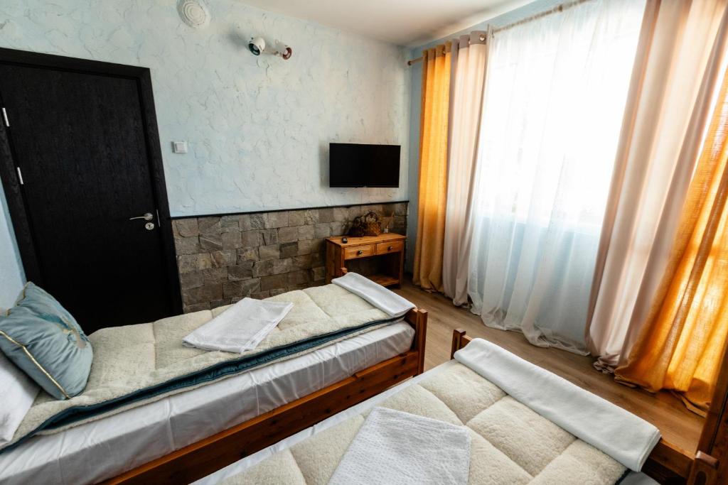 Уютна стая с две единични легла в River Rest Vetren, с телевизор, естествена светлина и модерни удобства