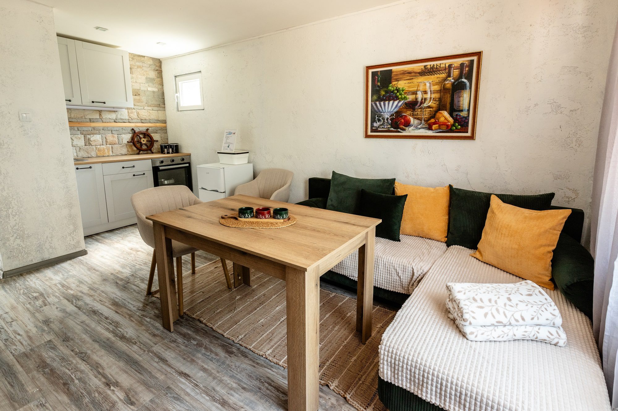 Къща за гости River Rest Ветрен – уютна дневна с напълно оборудвана кухня и комфортна зона за почивка с гледка към река Дунав.